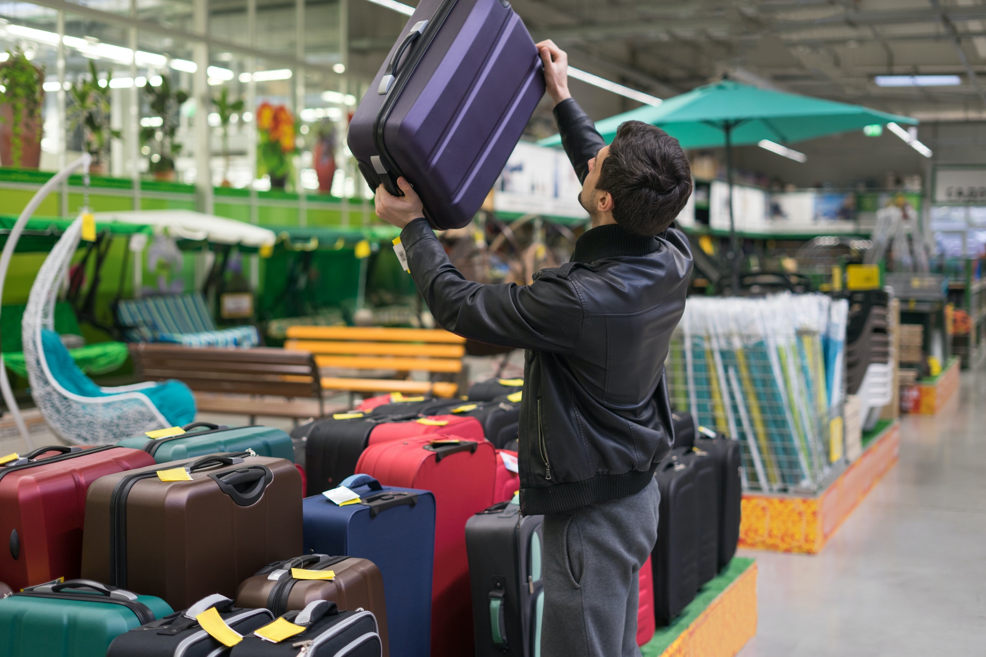 male customer choosing travel suitcase